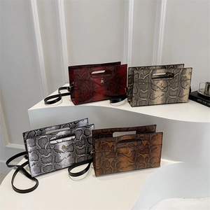 Chic snake-patterned envelope handbags in four colors displayed on white steps