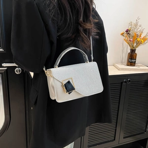 Sac à bandoulière pailleté argenté avec boucle géométrique sur une veste noire