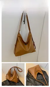 Detailed close-up showing the brown PU leather texture and triangular metal logo plaque