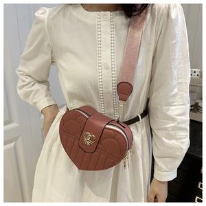 Detail of pink quilted heart bag with wing pattern and golden metal heart lock