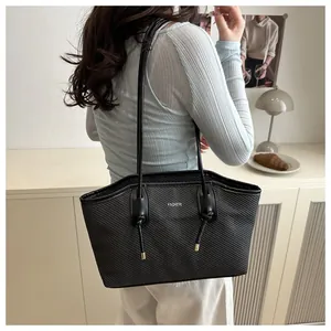 Close-up of black tote bag with diagonal twill texture and Fashion lettering