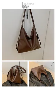 Detail of coffee brown faux leather tote with triangular metal logo and adjustable strap