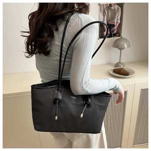 Détail du sac cabas noir avec poignée nouée, ferrures dorées et logo Fashion argenté