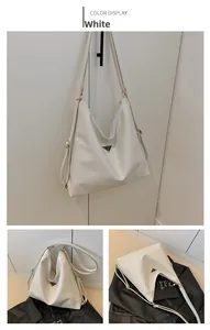 Detail of white large hobo bag with glossy leather texture and metal logo plaque