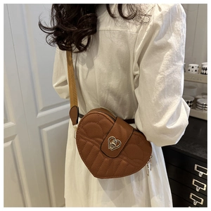 Brown heart-shaped crossbody bag with quilted pattern and adjustable fabric strap