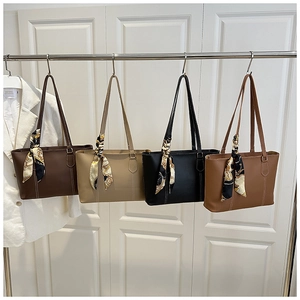 Detail view of large tote bags with contrast stitching and decorative silk scarves