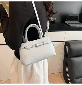 Detail of light blue lychee pattern leather bucket bag with silver metal buckle detail