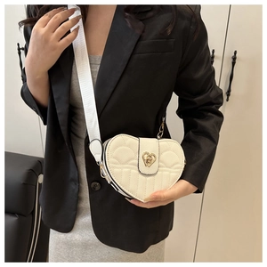 White heart-shaped quilted crossbody bag with metal twist lock and wide strap
