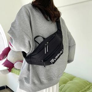 Black sporty crossbody saddle bag with TEVGRUNT lettering and adjustable shoulder strap