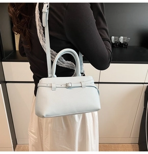 Detailed macro view of light blue lychee pattern leather bucket bag with silver buckles