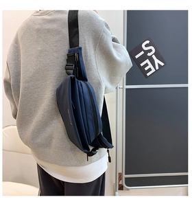 Modèle portant un grand sac bandoulière de sport en nylon imperméable bleu marine