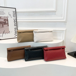 Minimalist woven envelope clutch bags in five colors on a wave display stand
