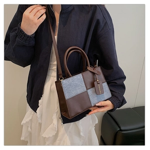 Detail of contrast color crossbody bag featuring grey tweed panels and brown leather handles