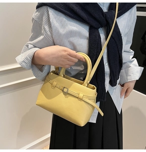 Detail of yellow lychee pattern bucket bag with silver buckle and adjustable strap