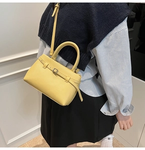 Litchi pattern yellow bucket bag shown with a long shoulder strap and round handle
