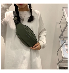 Détail de la sacoche bandoulière en nylon vert foncé avec sangle réglable et logo sport