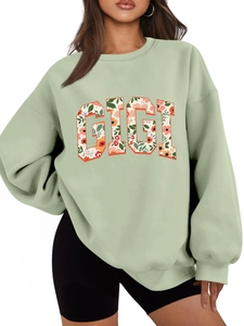 Détail de l'applique GIGI à fleurs sur un sweat-shirt oversize vert à col rond