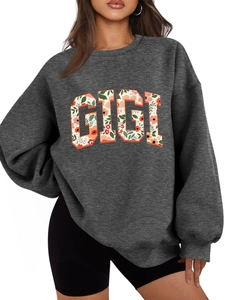 Détail du lettrage GIGI avec motif floral vintage sur sweat-shirt gris oversize