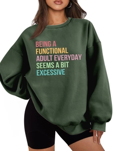 Detailed view of the colorful slogan print and thick fabric of the dark green sweatshirt