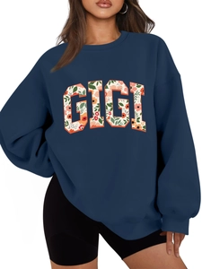 Gros plan du motif GIGI avec fleurs orange sur le sweat-shirt bleu marine pour femme