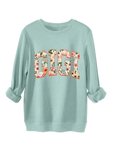 Détail du sweat vert menthe avec lettres GIGI remplies d'un motif floral chic