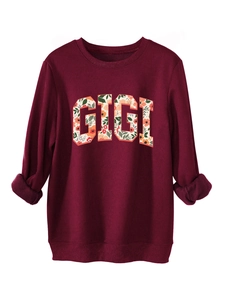 Détail du sweat-shirt Gigi bordeaux avec lettres florales et poignets côtelés