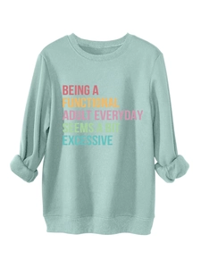 Detail of mint green sweatshirt featuring humorous printed slogan and soft fabric texture