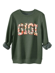 Détail du sweat vert foncé avec imprimé GIGI floral et doublure en polaire chaude