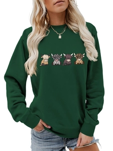 Detail of loose fit dark green sweatshirt featuring four colorful cartoon highland cows