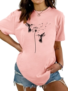 Detail eines rosa T-Shirts mit künstlerischem Aufdruck von Kolibris und Pusteblumen