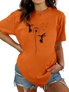 Detail von Löwenzahn und Kolibris Druck auf einem orangefarbenen Baumwoll-T-Shirt