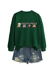 Detail of dark green crewneck sweatshirt featuring four highland cow cartoon illustrations