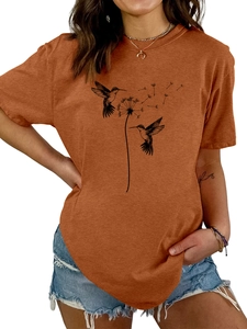 Detaildruck mit Kolibris und Pusteblume auf einem lässigen orangefarbenen T-Shirt