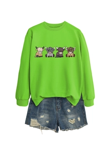 Detail view of neon green sweatshirt with four highland cows and ripped denim shorts