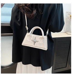 Vue portée du sac trapèze blanc crème avec détail d'étoile argentée et poignée ronde
