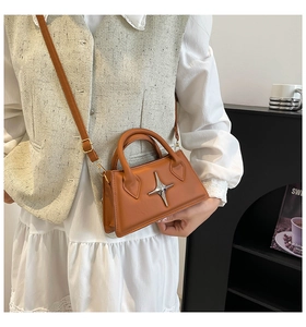 Détail du sac à main trapèze caramel avec étoile argentée et bandoulière réglable