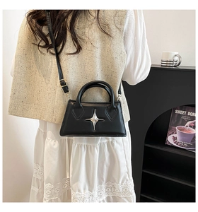 Détail d'un mini sac carré noir avec ornement d'étoile porté par un mannequin femme