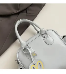 Close-up of light blue Boston tote bag with textured PU leather and heart charm