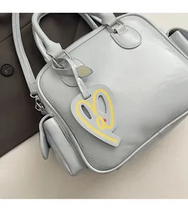 Detailed shot of grey PU leather Boston tote with vibrant yellow heart charm and handles