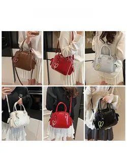 Detail of multi-color Boston tote bags with adjustable straps and heart charms