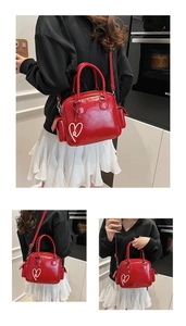 Detail der roten Lackleder-Boston-Tasche mit Seitentaschen und Herz-Anhänger