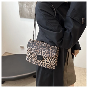 Detail of leopard print shoulder bag featuring textured finish and black metal chain strap