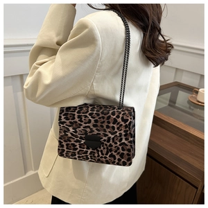 Détail macro du sac léopard avec chaîne en métal noir et boucle carrée élégante