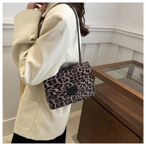Détail d'un sac bandoulière léopard vintage avec chaîne métallique sur mannequin