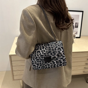 Retro leopard print crossbody bag with black metal chain strap on khaki blazer