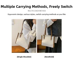 Detail of white crocodile embossed tote bag with brown contrast trim and handles