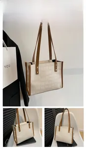 Detail of white crocodile embossed tote bag with spacious interior for books and items