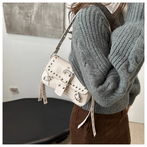 Detail of white vintage shoulder bag with silver studs and metal buckle accents