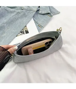 Internal view of silver skull embossed bag showing capacity for phone and cosmetics