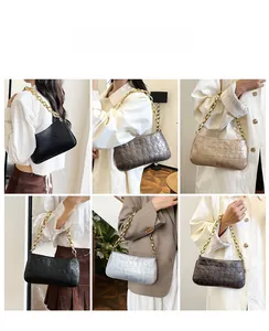 Detail of trendy skull embossed shoulder bag with chunky gold chain strap for women